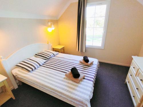 une chambre avec un lit avec deux poupées dessus dans l'établissement Maison au cœur d'un village vacances proche golf port et plage - 5 pers, à Saint-Hilaire-de-Talmont