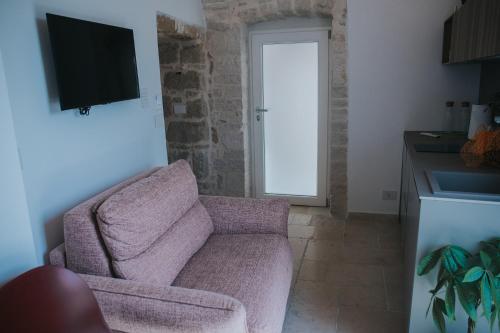 a living room with a couch and a tv at Blu Marina Apartment in Giovinazzo