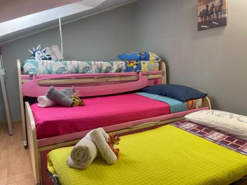 een slaapkamer met 2 stapelbedden met kleurrijke lakens bij Villa rosa appartamento in Montesilvano