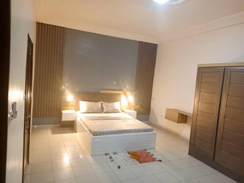ein Schlafzimmer mit einem Bett in einem Zimmer in der Unterkunft Appartement à Entrée Personnelle Abomey-Calavi ZOPAH in Abomey-Calavi