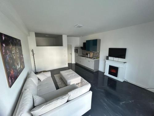 uma sala de estar com um sofá branco e uma lareira em Modern eingerichtetes Apartment zum entspannen und wohlfühlen em Oldenburg