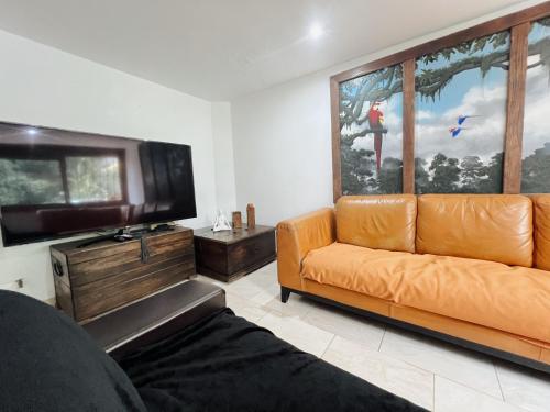 a living room with a couch and a flat screen tv at Casa Céntrica a 5 min Metro y Mayorca in Envigado