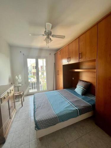une chambre avec un lit et un ventilateur de plafond dans l'établissement Maison avec piscine à 3min à pied de la mer, à Canet