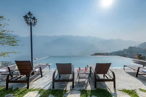 a group of chairs and a table next to the water at Sapa Soleil Hotel in Sa Pa