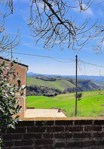 a brick wall with a view of a green field at Casa rustica con vista meravigliosa in Offida