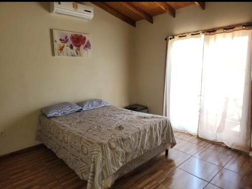 una camera da letto con un letto e una grande finestra di Corrales House a Tela