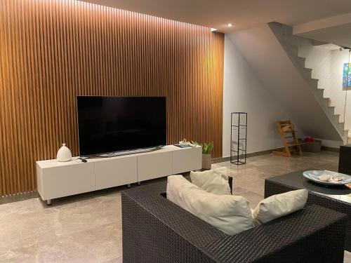 a living room with a flat screen tv on a wall at Eagle Vacation Home in Palm-Eagle Beach