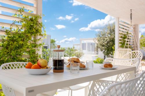 - une table blanche avec un bol de fruits sur le balcon dans l'établissement Buqez 58 - Drage villas, à Drage