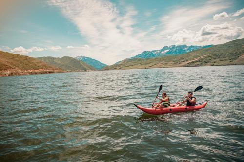 two people in a red canoe on a lake at Homestead Resort in Midway
