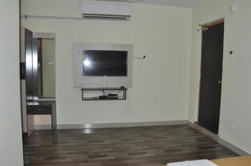 a room with a flat screen tv on a wall at Srirathna Temple View Inn in Thanjāvūr
