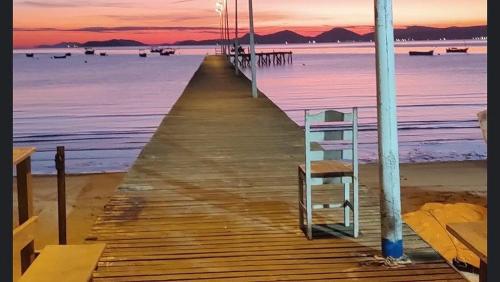 a wooden pier with a ladder on the beach at Casa espaçosa e aconchegante Cama King e ar condicionado in São José