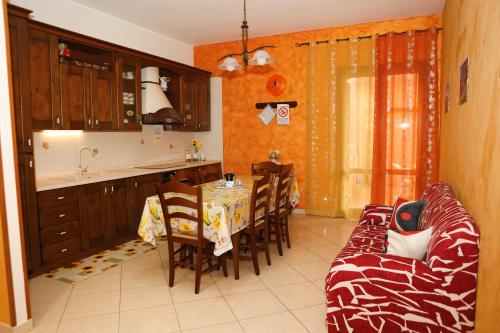 潘泰萊里亞的住宿－LE CASE DI CICCIO - Casa Girasole，厨房以及带桌子和沙发的用餐室。