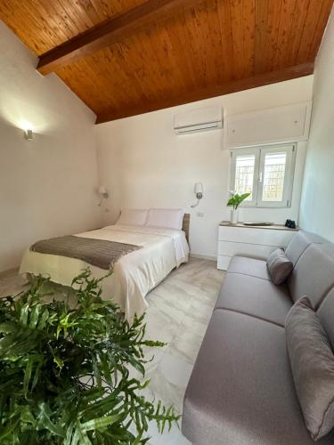 um quarto com uma cama e um sofá em B&B Spiaggia Le Dune em Margherita di Savoia