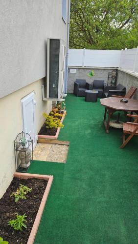 a patio with green grass and a table and chairs at Chez Marie et Daniel in Vrigne-aux-Bois