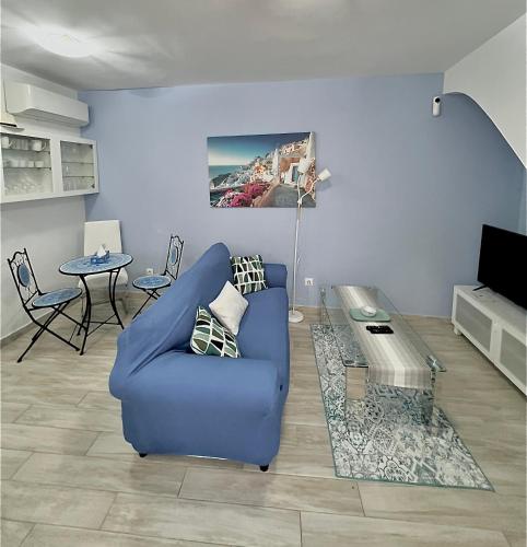 a living room with a blue chair and a table at Casa San Miguel in Estepona