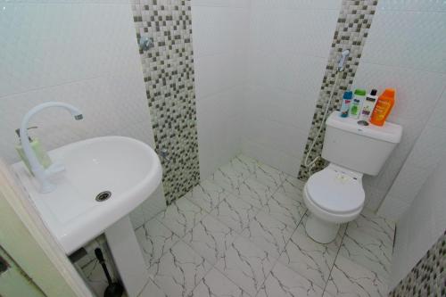 a bathroom with a sink and a toilet and a shower at Beau Fahy Nyali studio apartment in Mombasa