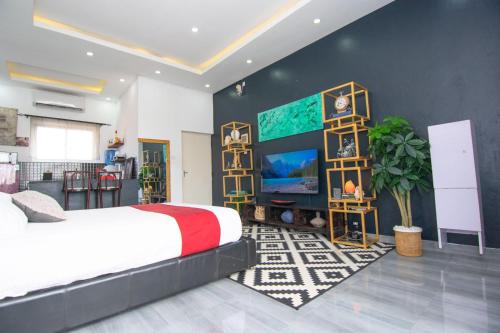 a bedroom with a large bed and a tv at Beau Fahy Nyali studio apartment in Mombasa