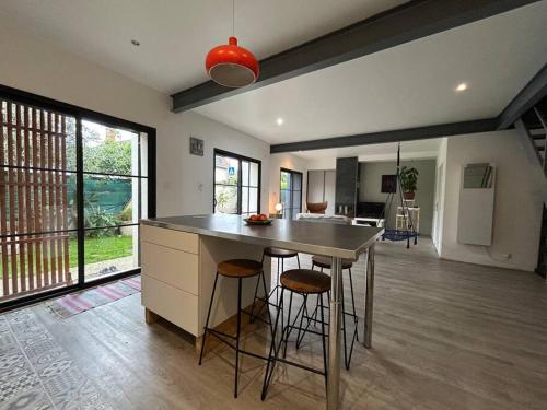 une cuisine avec une table et des tabourets dans une pièce dans l'établissement Villa moderne cosy, à Toulouse