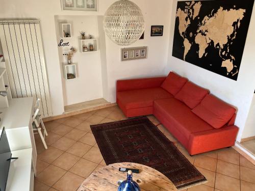 sala de estar con sofá rojo y mesa en Tuscia Home Backpackers, en Orte