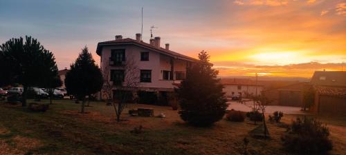 a building with a sunset in the background at Hotel Valdelinares (Soria) in Valdelinares