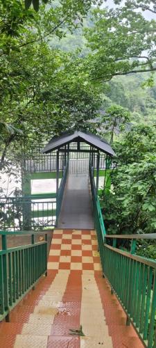 a walkway leading to a bridge with a canopy at The Serene Cottage in Viripara