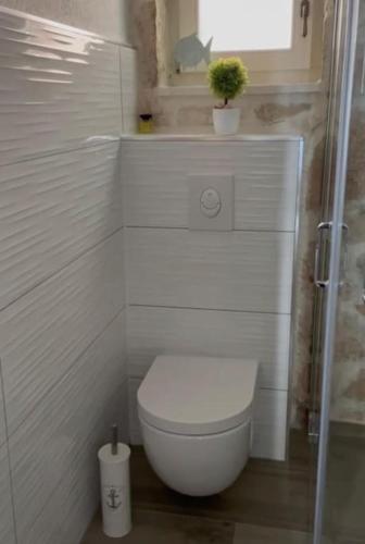 a white bathroom with a toilet and a plant at Villa Ocean View of Kali - Erste Meerreihe mit Pool in Kali