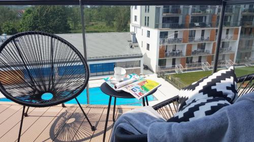 vistas a un balcón con una silla y una piscina en Michano Apartamenty Premium, en Kołobrzeg