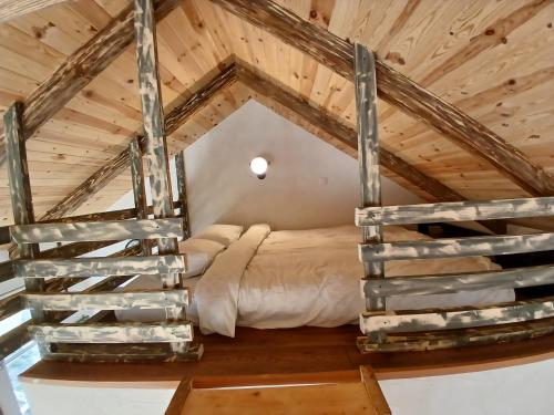 a bedroom in a loft with a bed and stairs at Mica fermă veselă in Câmpulung Moldovenesc