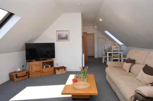 a living room with a couch and a tv at Heronlea Cottage in Dunoon