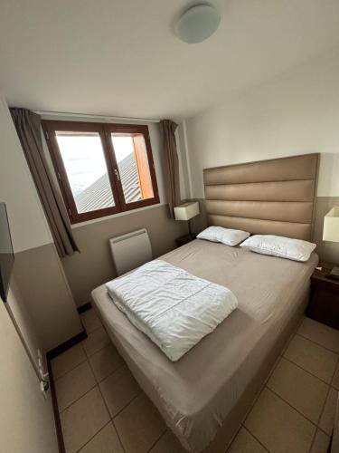 - une chambre avec un grand lit et une fenêtre dans l'établissement Beau 2 pièces, au pied des pistes Résidence Adonis, à Valberg