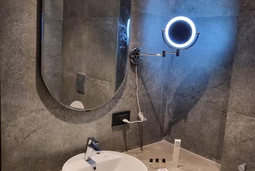 a bathroom with a round mirror and a sink at GT Stay Studio 1802 in Ghaziabad