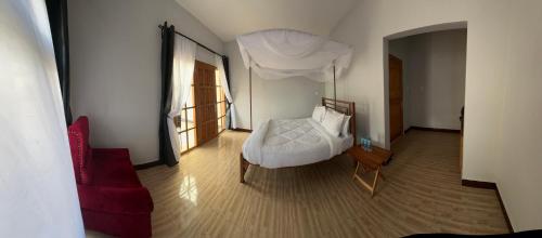 1 dormitorio con cama blanca y sofá rojo en Manyara Exclusive Safari Lodge en Mto wa Mbu