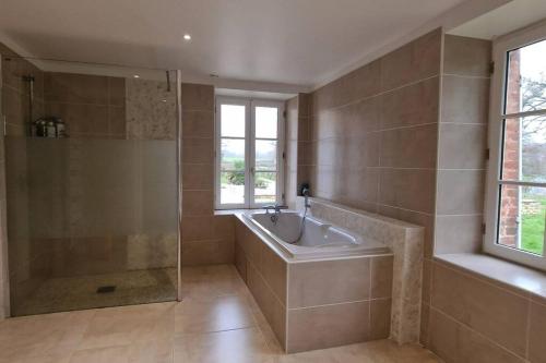 a bathroom with a shower and a tub and a sink at Charmante maison au coeur du Limousin - Comme à la maison in Lussac-les-Églises