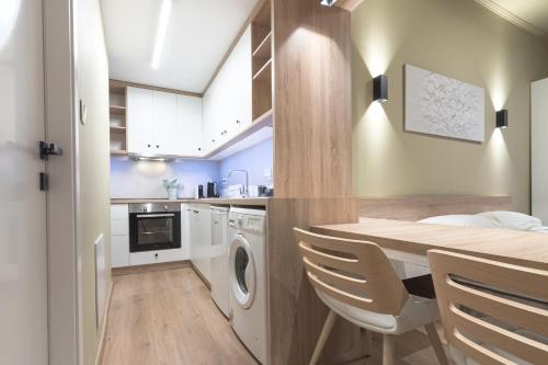 a kitchen with a table and a washing machine at No125 - City Centre Studio Apartment in Orestiada