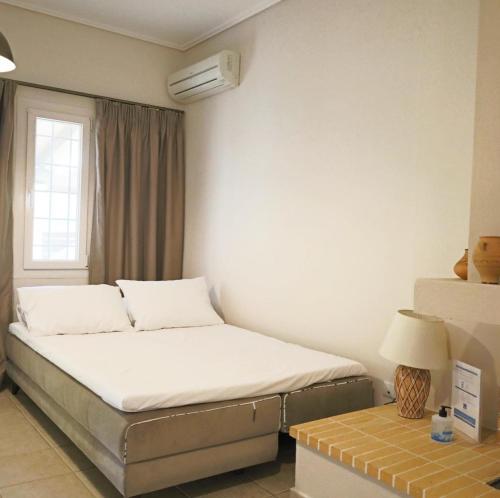 a small bedroom with a bed and a table at Villa Victoria Boutique Apartments in Sivota