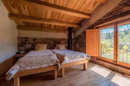 1 dormitorio con cama y ventana grande en La Paradella - Apartamento de uso turístico, en Arbúcies