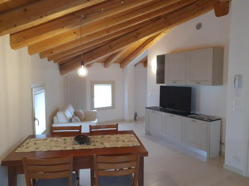 eine Küche und ein Wohnzimmer mit einem Tisch und einem TV in der Unterkunft CASA TOFFOLI SOLIGO - locazioni turistiche in Soligo