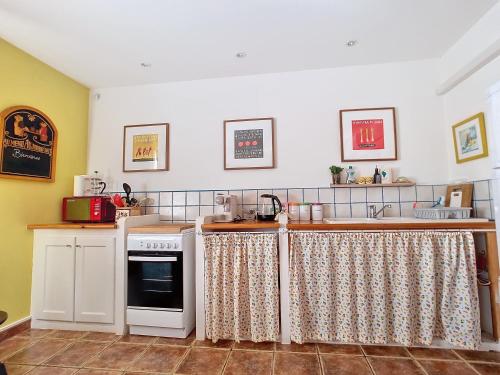 une cuisine avec une cuisinière et un comptoir dans l'établissement Apartment for adventures in Languedoc, à Cessenon