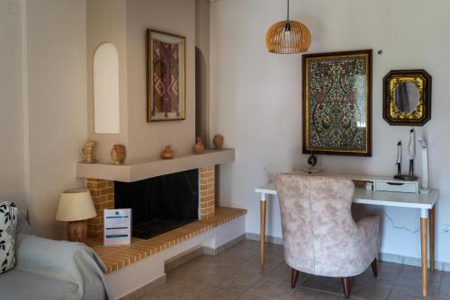 a living room with a desk and a fireplace at Villa Victoria Boutique Apartments in Sivota