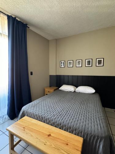 1 dormitorio con cama y mesa de madera en Depa de diseño Zamora, Mich., en Zamora de Hidalgo