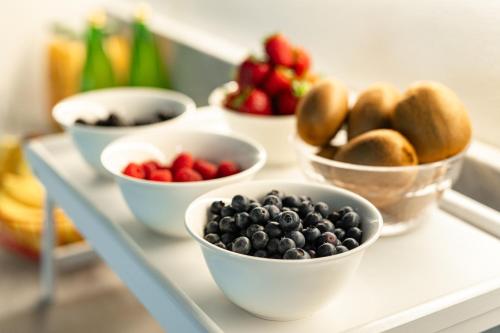 a shelf with bowls of blueberries and bread at Villa Fedora Luxury Suites in Lucca