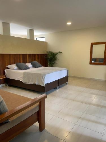 - une chambre avec un grand lit et un miroir dans l'établissement Casa Fuego, à La Pintada