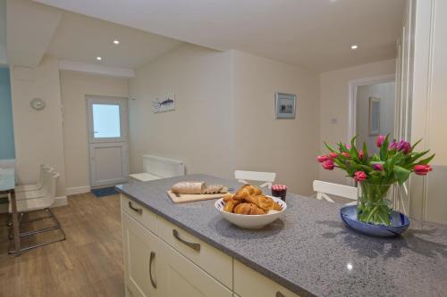 a kitchen with a counter top with a bowl of bread at 4 The Salcombe in Salcombe