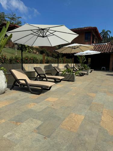a row of lounge chairs and umbrellas on a patio at Casa Fuego in La Pintada