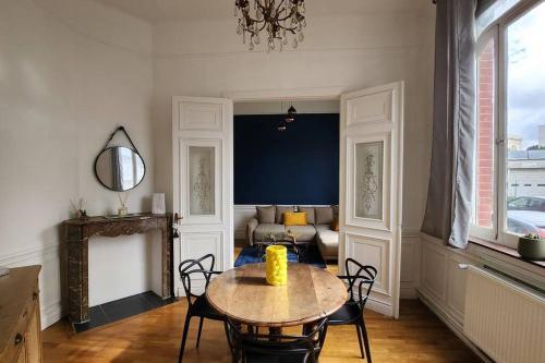 a living room with a table and a couch at Artiste in Douai