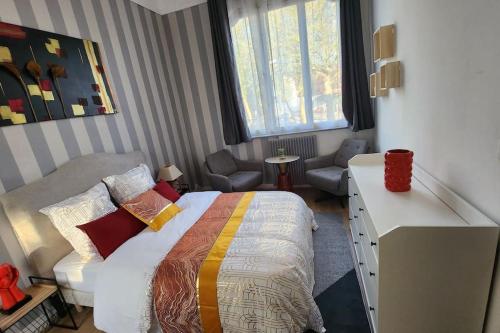 een slaapkamer met een bed, een bureau en een stoel bij Artiste in Douai