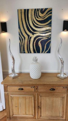 two lamps on top of a wooden cabinet with a painting at Artiste in Douai