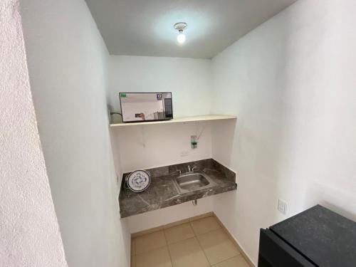 una pequeña cocina con fregadero y microondas en Apartamentos Amplios Alfa # 238, en Monterrey