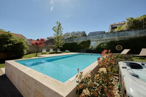 a large swimming pool in a yard with plants at Aparthotel Oporto Anselmo in Porto