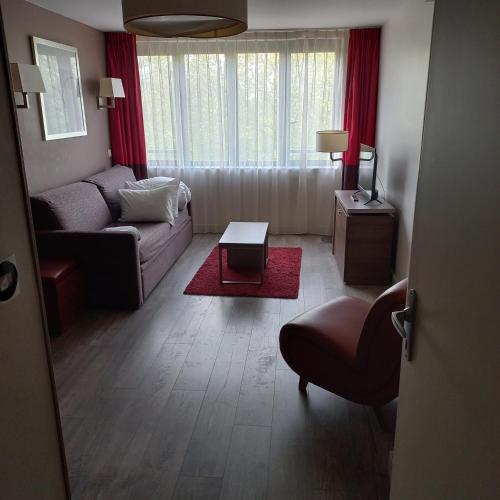 a living room with a couch and a table at B&B HOME Caen Centre Gare in Caen